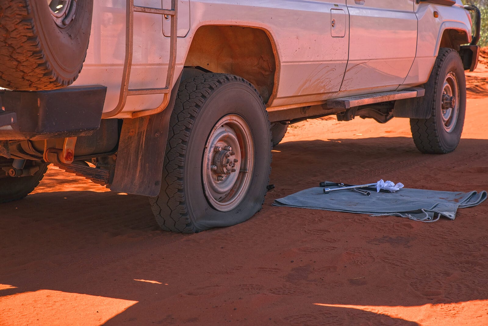 All wheel drive has flat tire in outback preparing to use Fix A Flat