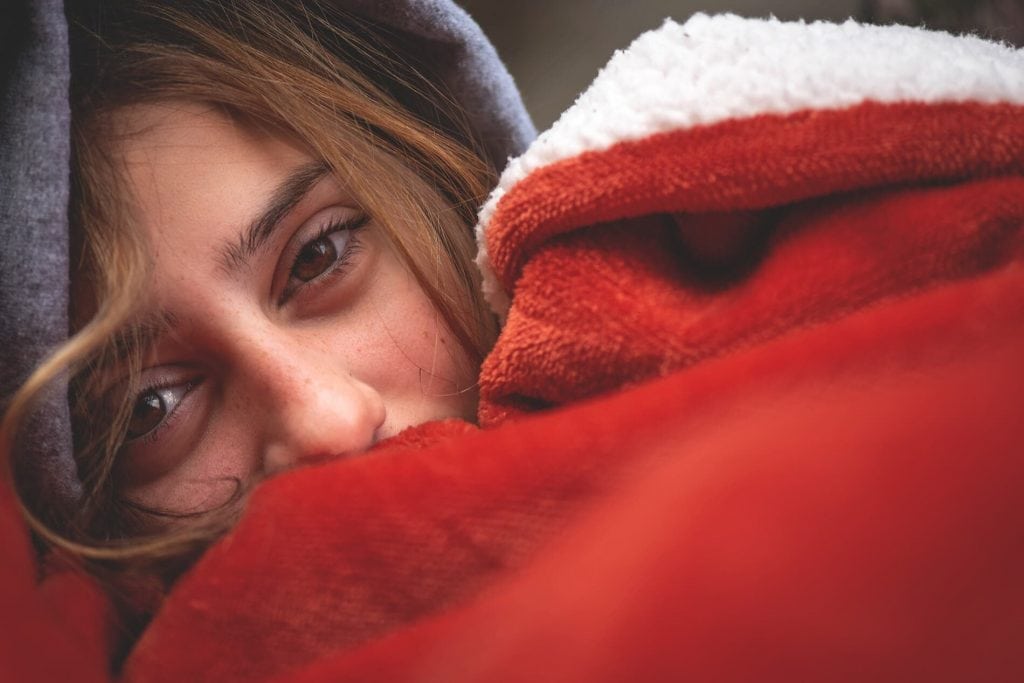 Female camper with red warm heating blanket